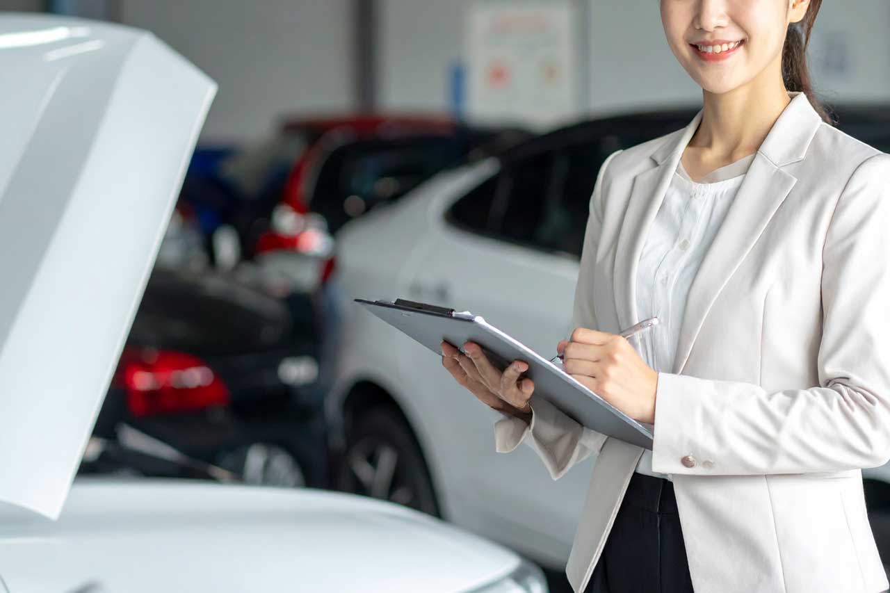 車の状態を確認しながら記録をとるスタッフ