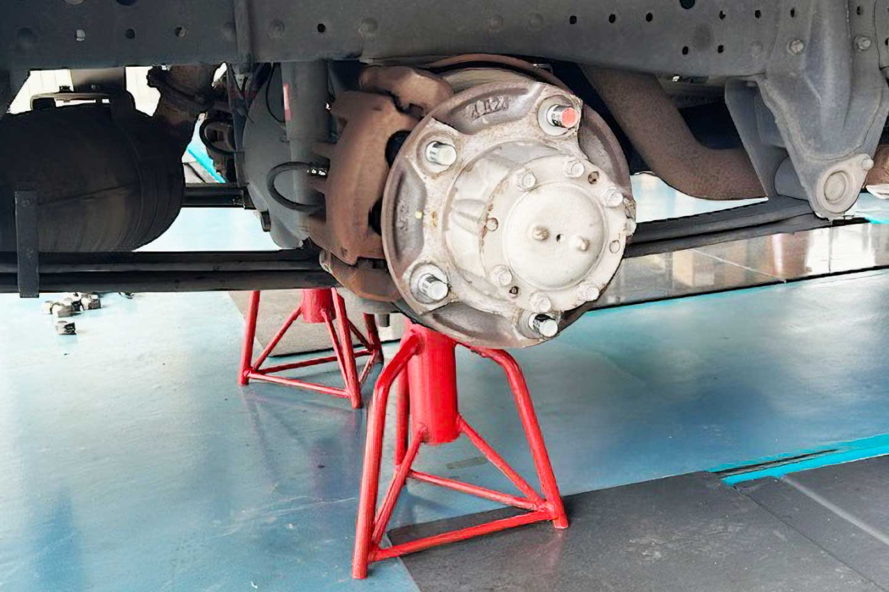タイヤを取り外し、専用のスタンドで車体を支えて行う足回り部品の分解整備の様子